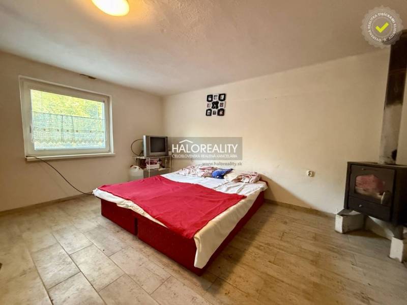 Schlafzimmer mit Herd, Fernseher und Bett, Boden mit Holzdekor.