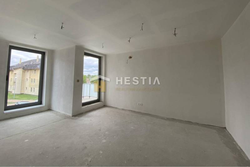 Ein geräumiges Zimmer mit zwei großen Fenstern in einer 2-Zimmer-Wohnung.