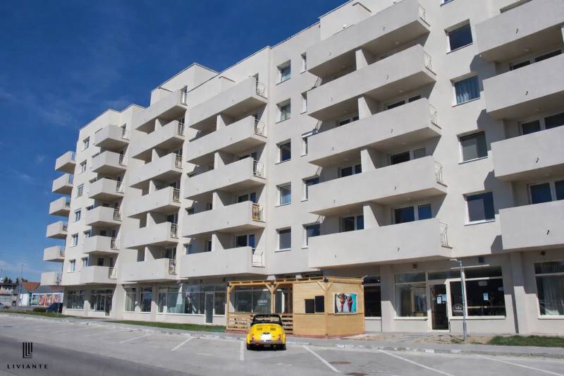Mehrfamilienhaus in der Dukelská-Straße in Bernolákovo mit Parkplätzen und Gastronomiebereichen.