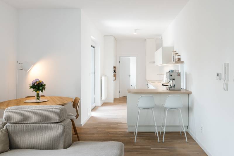 Küche mit Tisch, Sofa und Holzboden in einer 4-Zimmer-Wohnung.