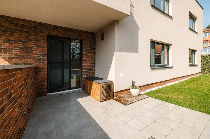Die Terrasse der 4-Zimmer-Wohnung auf der Cesta na Klanec in Bratislava - Lamač mit grünem Rasen.