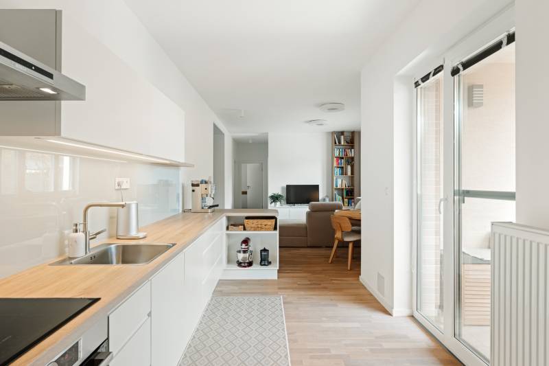 Küche mit Holzboden und Wohnzimmer in einer 4-Zimmer-Wohnung.