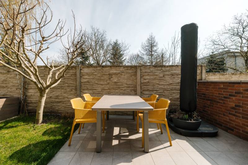 Die Terrasse einer 4-Zimmer-Wohnung auf der Cesta na Klanec in Lamač, mit modernen Möbeln und einem Baum.
