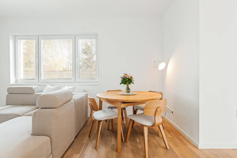 Essbereich mit Tisch und Stühlen in einer 4-Zimmer-Wohnung mit Holzboden.
