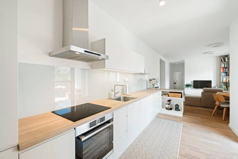 Küche in einer 4-Zimmer-Wohnung mit Holzboden und heller Ausstattung.