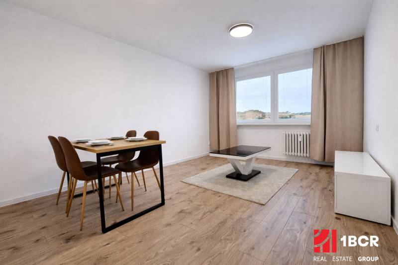 Esstisch und Couchtisch auf einem Boden mit Holzdekor in einer Zweizimmerwohnung.