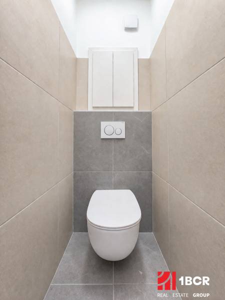 Minimalistisches Badezimmer mit Wand-WC und Fliesen in einer Zweizimmerwohnung.