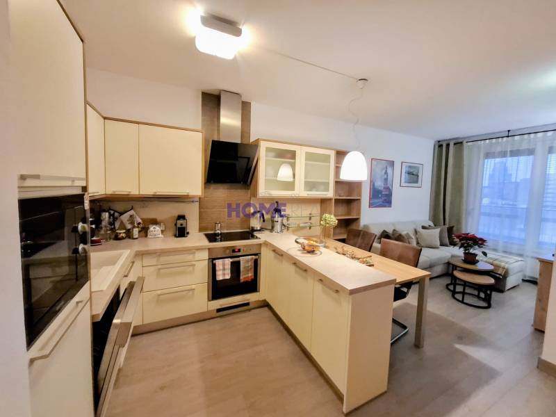 Küche in einer 2-Zimmer-Wohnung mit Kücheninsel und eingebauten Geräten.