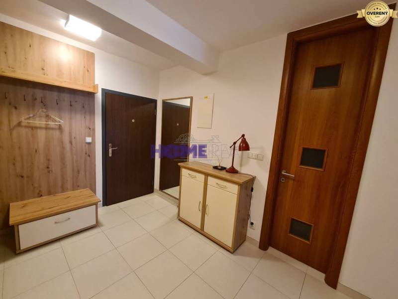 Flur in einer 2-Zimmer-Wohnung mit Schuhschrank und Garderobenwand in Holzdekor.