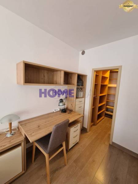 Ein Schreibtisch mit Stauraum in einer 2-Zimmer-Wohnung mit einem Boden in Holzoptik.