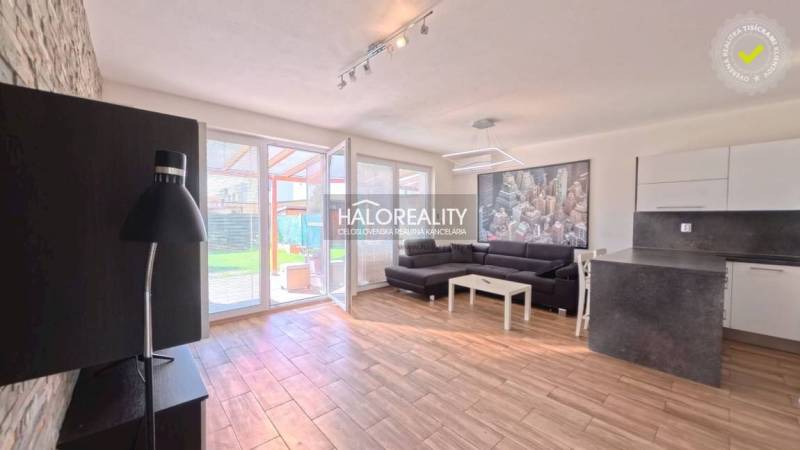 2-Zimmer-Wohnung mit Holzboden, Sofa und Kochnische.