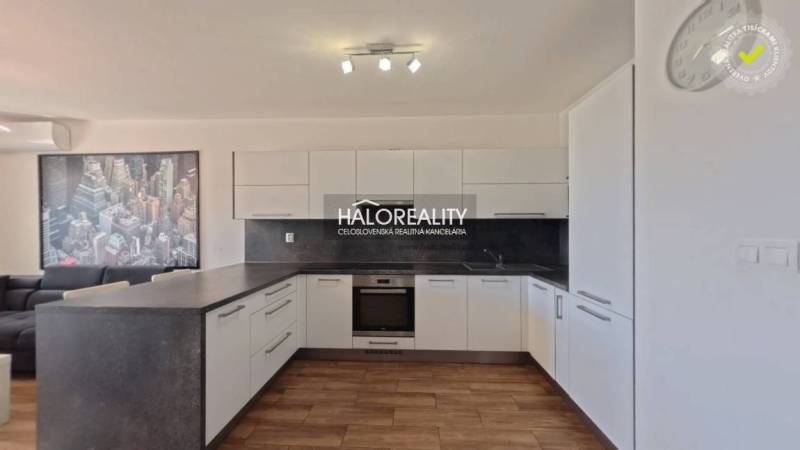 Küche in einer 2-Zimmer-Wohnung mit Holzboden, weißen Schränken und einem Bild.