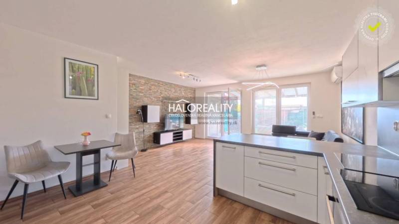 Helles Wohnzimmer in einer 2-Zimmer-Wohnung mit Holzboden und Kücheninsel.