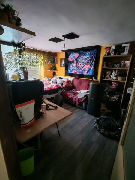 Ein Zimmer in einem Einfamilienhaus mit bunter Dekoration und Holzboden.