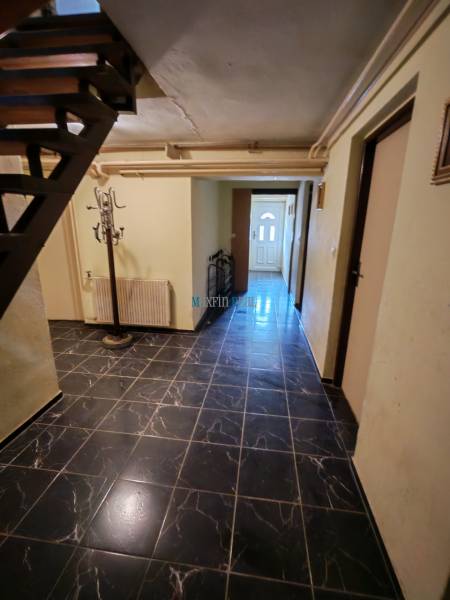 Innenraum mit schwarzen Wandfliesen und Treppe in einem Einfamilienhaus.