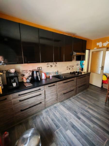 Küche mit schwarzen Schränken und Holzboden in einem Einfamilienhaus.