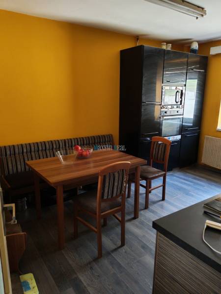 Esszimmer in einem Einfamilienhaus mit Holztisch, Stühlen und Boden mit Holzdekor.