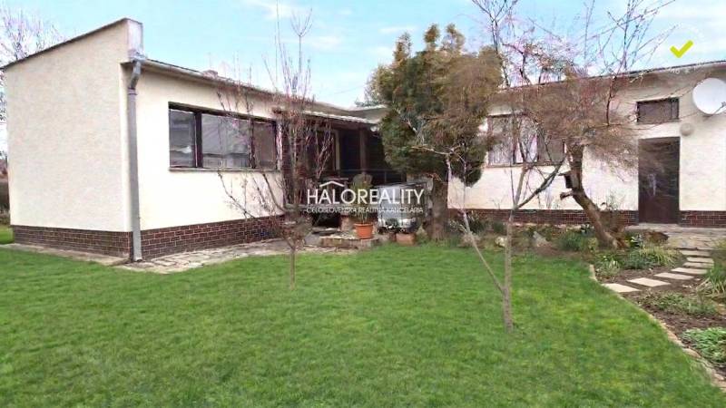 Ein Einfamilienhaus in Poltár mit Garten und Bäumen, gepflegtem Rasen.