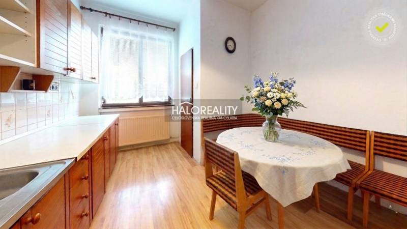 Küche in einem Einfamilienhaus mit Holzboden und Blumendekoration.