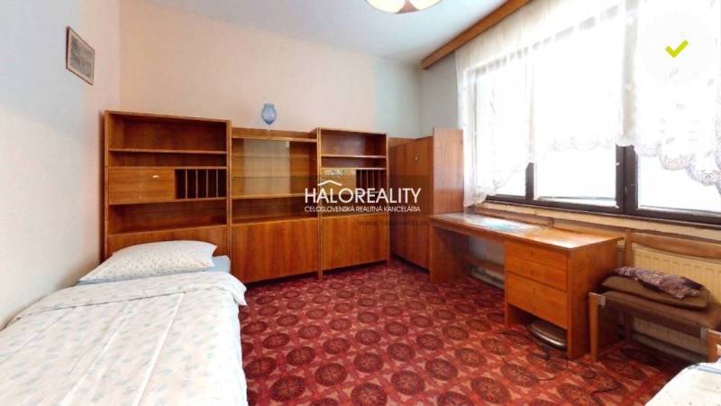 Ein Zimmer mit Teppichboden, Holzmöbeln in einem Einfamilienhaus.