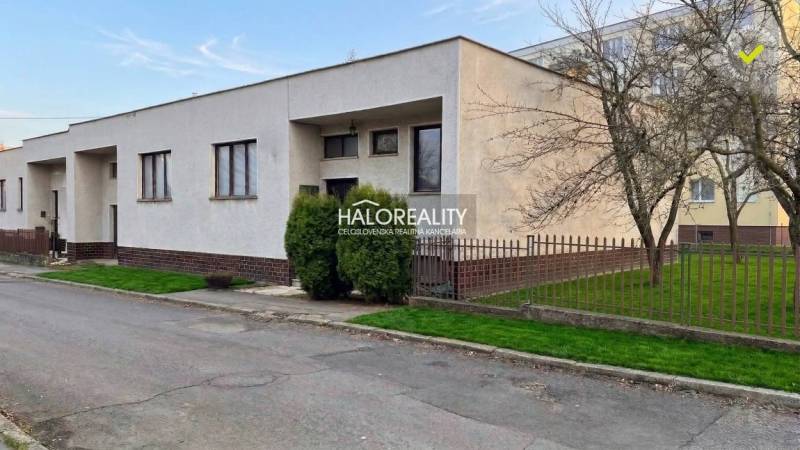 Ein Einfamilienhaus in Poltár mit Vorgarten, Umzäunung und gepflegtem Rasen in einer ruhigen Straße.