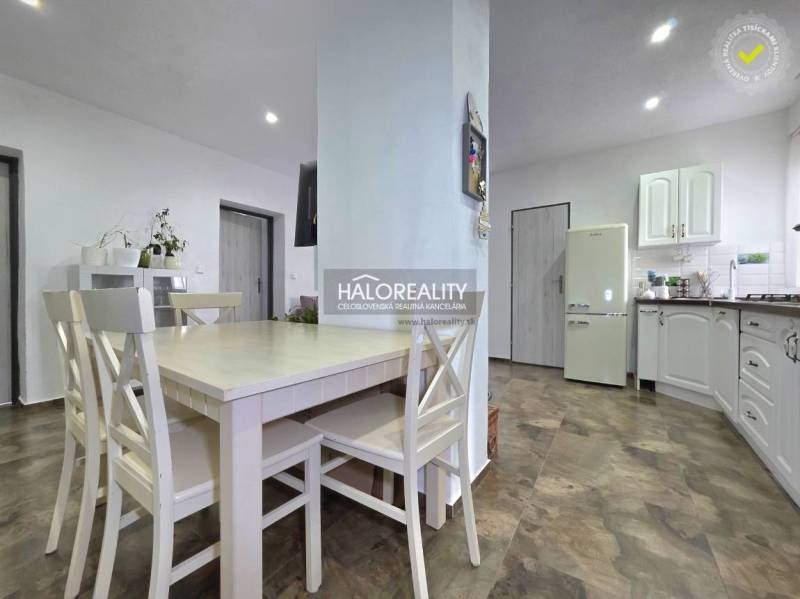 Küche in einem Einfamilienhaus mit Holzboden und weißen Möbeln.