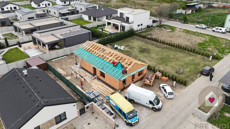 Der Bau eines Einfamilienhauses in der Karasova-Straße in Senec, umgeben von fertigen Häusern.