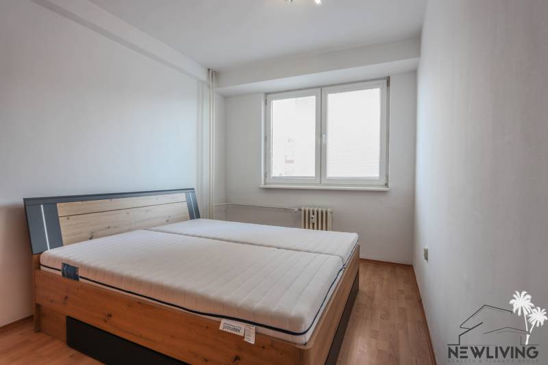 Schlafzimmer mit Bett und Holzboden in einer 2-Zimmer-Wohnung.