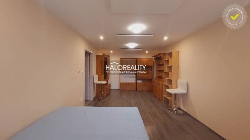 Ein Zimmer in einem Einfamilienhaus mit einem Boden in Holzoptik und Holzmöbeln.