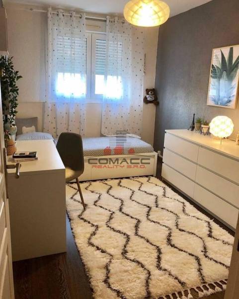 Kinderzimmer mit Schreibtisch, Teppich und Boden mit Holzdekor in einem Einfamilienhaus.