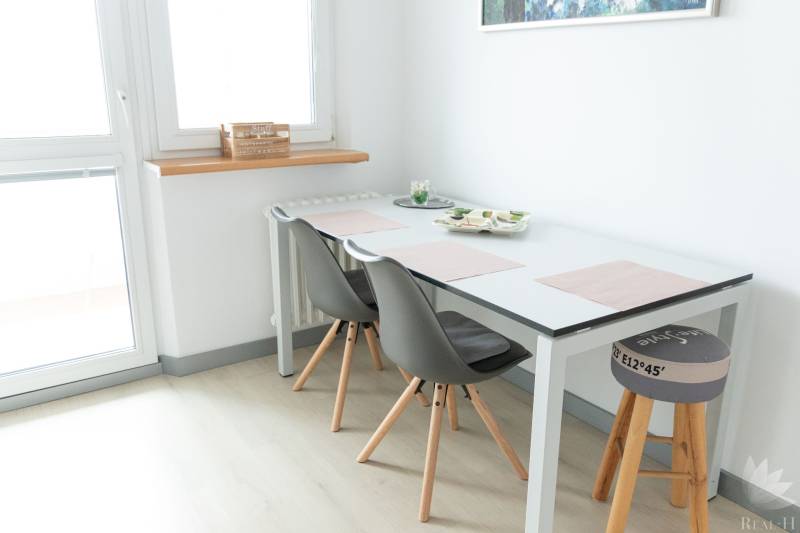 Essbereich mit Tisch und Stühlen in einer 4-Zimmer-Wohnung, Boden mit Holzdekor.