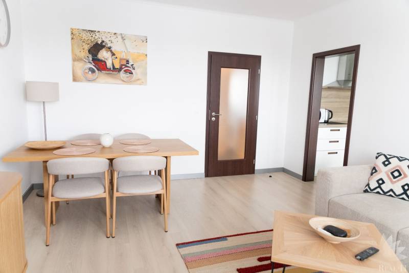 Esszimmer in einer 4-Zimmer-Wohnung mit Holzboden und einem Kunstgemälde an der Wand.
