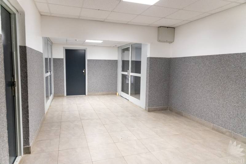 Flur mit Fliesen und weißen Deckenpaneelen in einer 4-Zimmer-Wohnung.