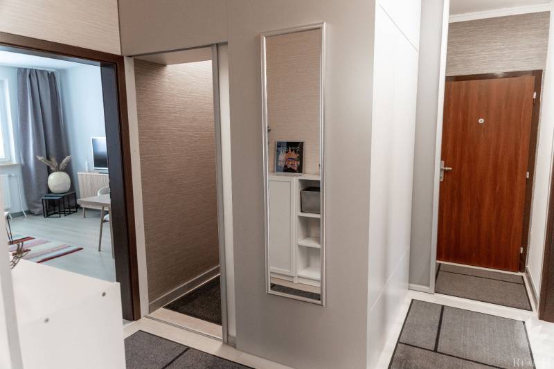 Eingangsbereich in einer 4-Zimmer-Wohnung mit Holzboden und Spiegel.