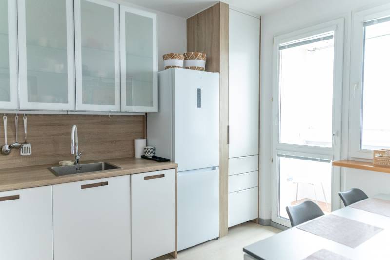 Geräumige Küche in einer 4-Zimmer-Wohnung mit weißen Schränken und großem Fenster.