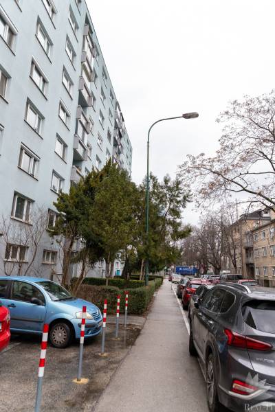 Mehrstöckiges Wohngebäude in der Ondavská-Straße in Bratislava - Nivy, umgeben von Autos und Bäumen.