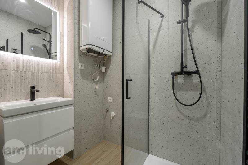 Badezimmer mit Duschkabine und Boden mit Holzdekor in einer 3-Zimmer-Wohnung.