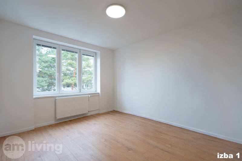 Ein geräumiges Zimmer mit einem großen Fenster und einem Boden in Holzoptik in einer 3-Zimmer-Wohnung.