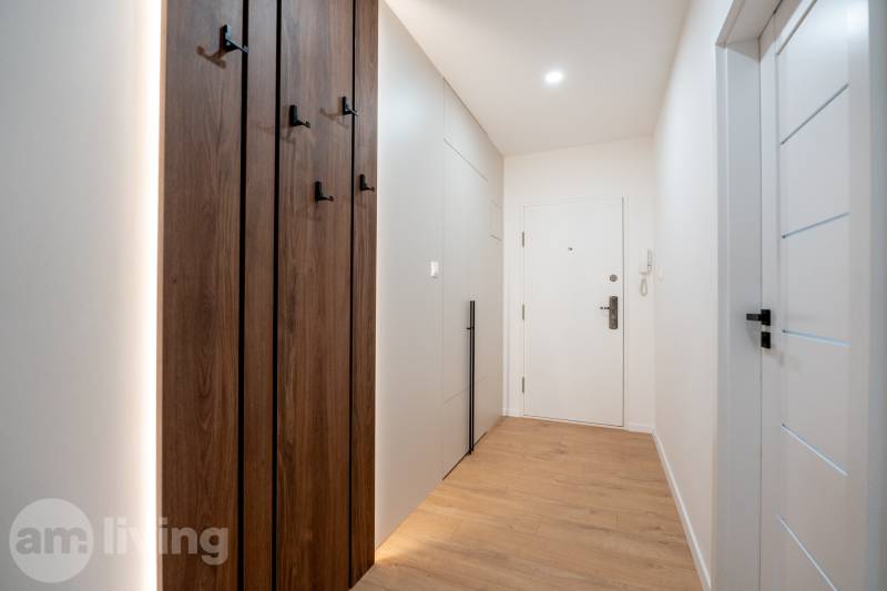 Ein schmaler Flur mit Einbauschränken und einem Boden in Holzoptik in einer 3-Zimmer-Wohnung.