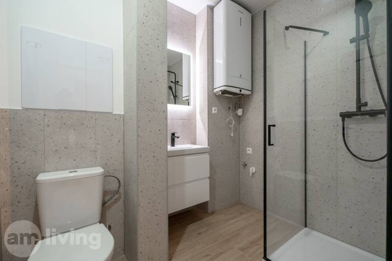 Badezimmer in einer 3-Zimmer-Wohnung mit Holzboden und Duschkabine.