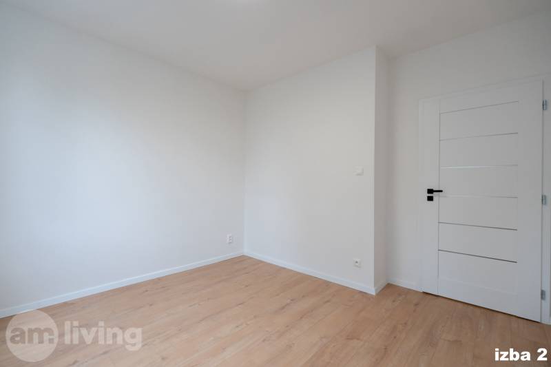 Ein Zimmer in einer 3-Zimmer-Wohnung mit einem Boden in Holzoptik und weißen Wänden.