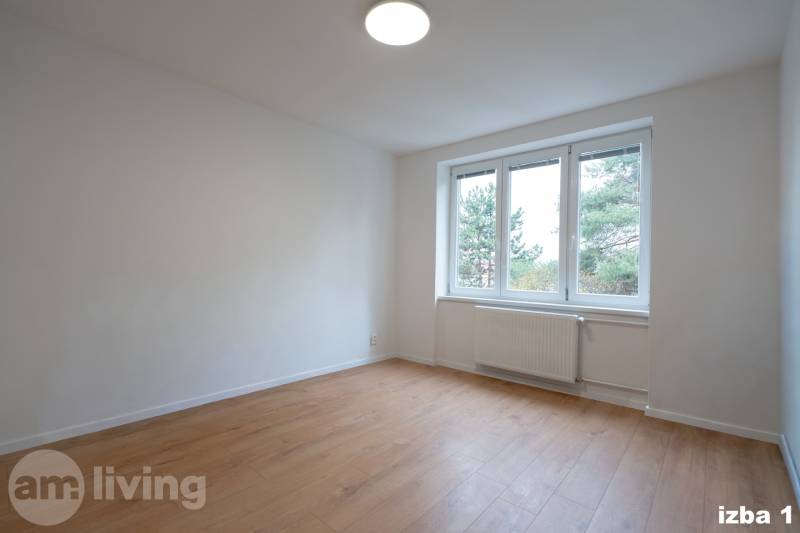 Geräumiges Zimmer mit großem Fenster und Holzboden in einer 3-Zimmer-Wohnung.