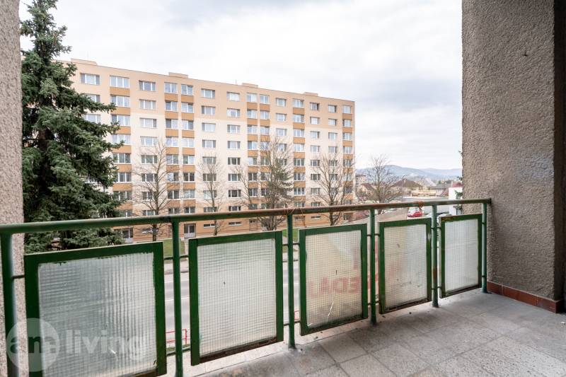Der Balkon einer 3-Zimmer-Wohnung in Dubnica nad Váhom mit Blick auf ein Wohngebäude und Grünflächen.