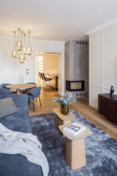 Wohnzimmer in einer 4-Zimmer-Wohnung mit Holzboden und stilvoller Beleuchtung.