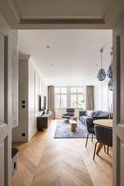 Wohnzimmer in einer Vierzimmerwohnung mit Holzboden und bequemen Möbeln.