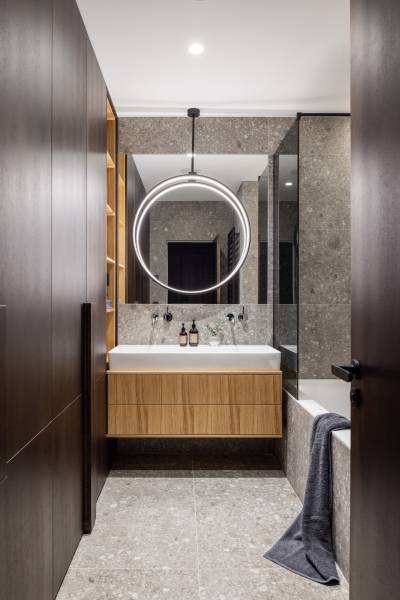 Badezimmer mit hängendem Waschbecken und Beleuchtung in einer 4-Zimmer-Wohnung, verwendet Holzdekor.