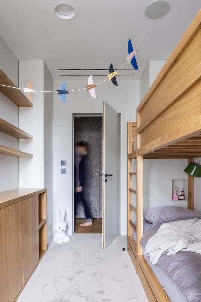 Ein Kinderzimmer mit einem Etagenbett, Holzmöbeln und Spielzeug in einer Vierzimmerwohnung.