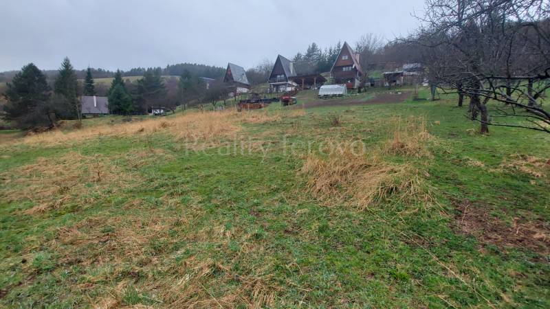 Weitläufige Erholungsgrundstücke in Púchov mit Hütten und von Bäumen gesäumtem Grün.