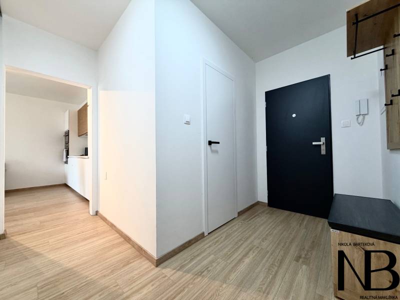 Innenraum einer Einzimmerwohnung mit Holzboden und weißen Wänden.