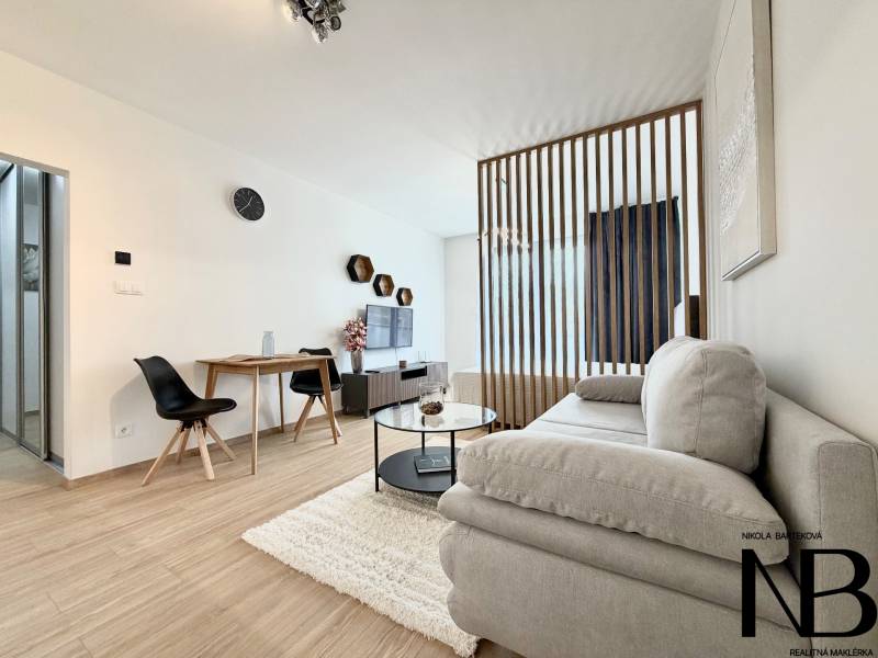 Stilvolle 1-Zimmer-Wohnung mit Holzboden, Sofa und Essecke.